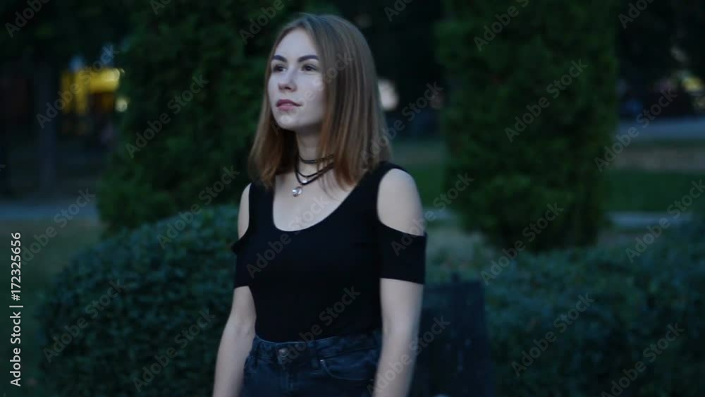 charming girl with short hair looks ahead and walking down the street charming girl with short hair looks ahead and walking down the street