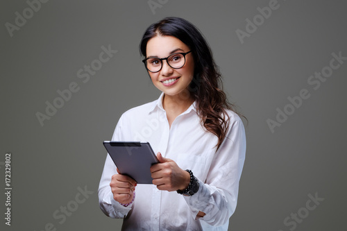 The attractive female student holds tablet PC.