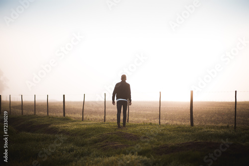 Silhouette guy standing at misty fence