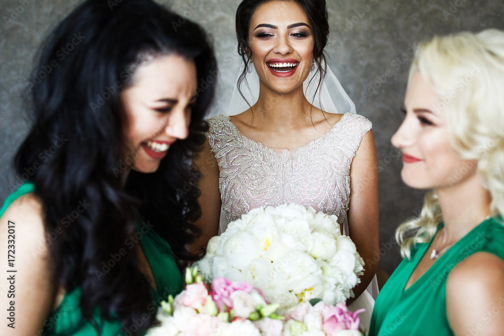 Bridesmaids look in each other eyes standing before smiling bride Bridesmaids look in each other eyes standing before smiling bride