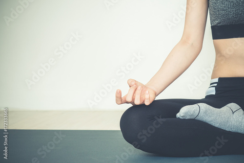 Young beautiful asian woman do yoga pose sitting on yoga mat in fitness class