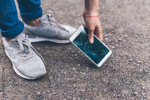 Φωτογραφία woman dropped mobile phone on the ground and smashed the screen