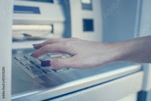 Hand of woman pressing keyboard at local  cash machine. Close up.