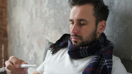 Close up of sick man checking temperature