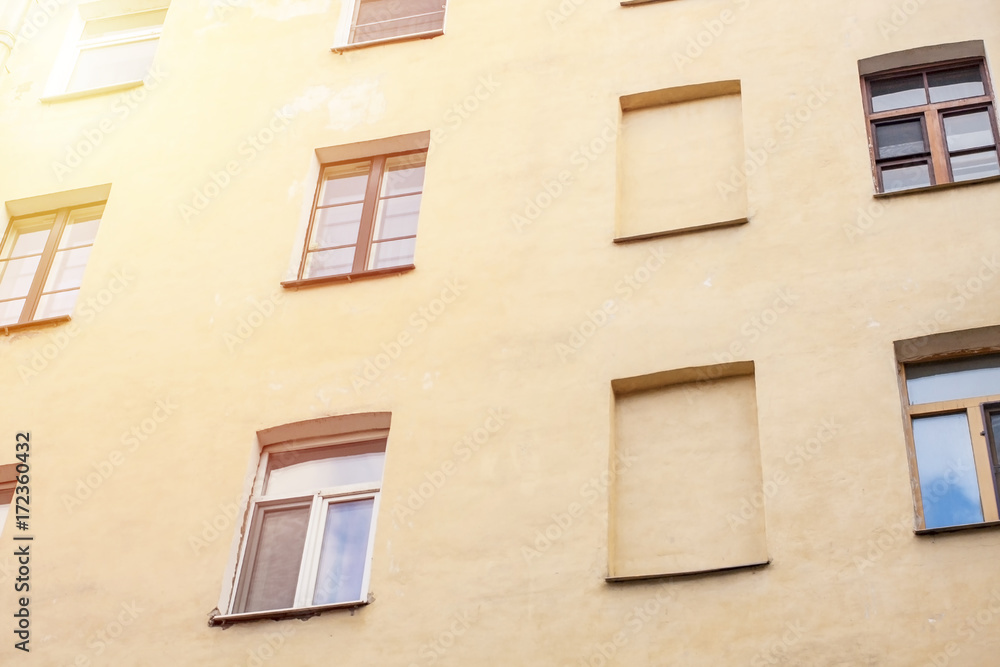 Windows on yellow wall of european appartments.