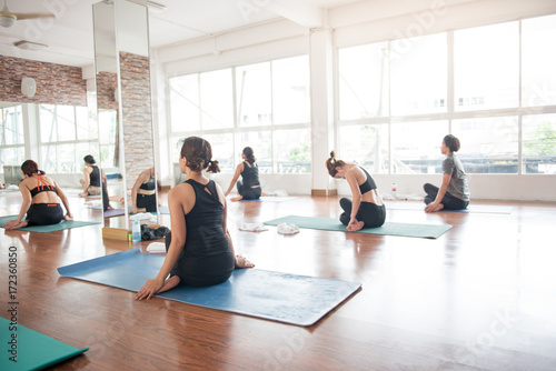 Group women stretching and practices yoga in a class, healthy lifestyle and fitness concept