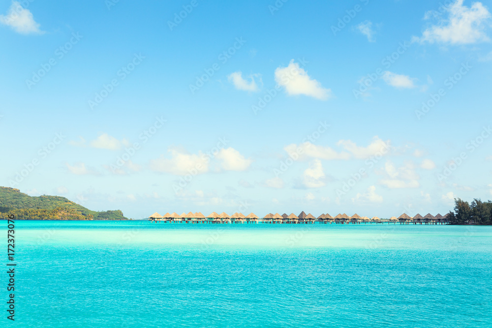 Stunning view of blue turquoise lagoon and far bungalows on background of Bora Bora island, French Polynesia