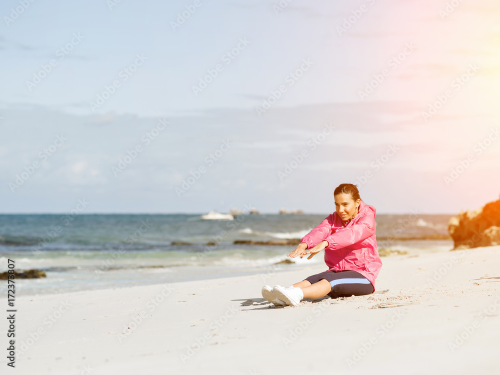 Young woman at the beach doing exercises