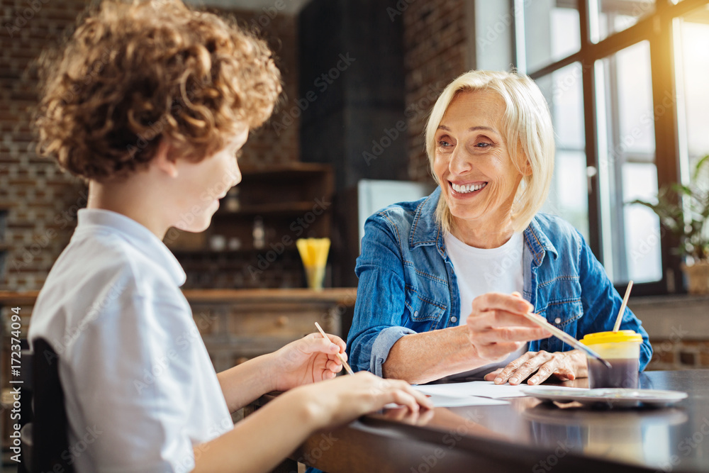Fototapeta premium Beautiful elderly lady smiling while talking with grandchild