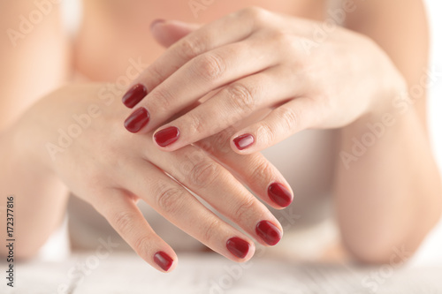 Young beauty with red painted nails  very relaxed