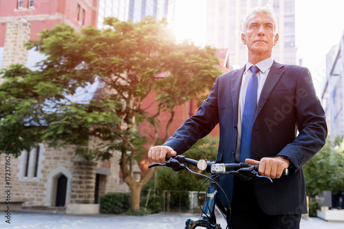 Successful businessman riding bicycle