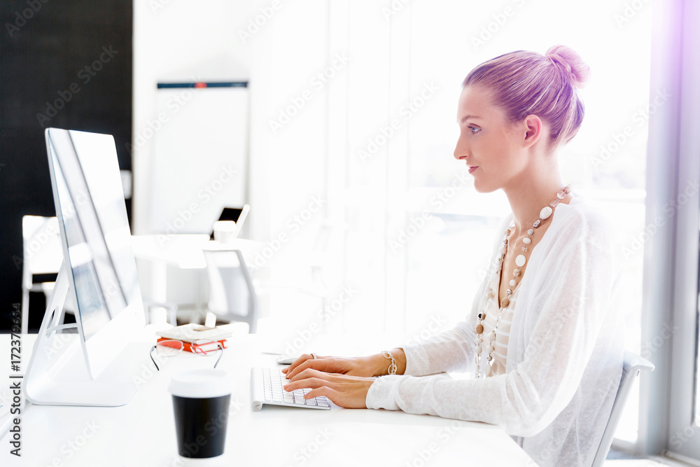 Attractive office worker sitting at desk Attractive office worker sitting at desk