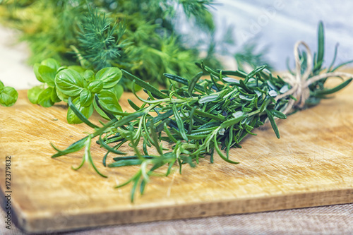 bunch of green scented rosemary on wooden background
