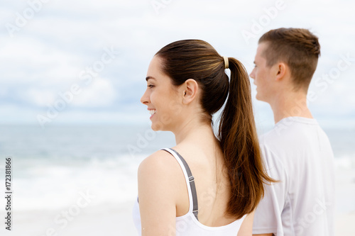 Young couple looking thoughtful while standing next to each other on beach