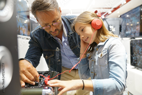 Father and daughter checking music in multimedia store