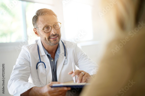 Doctor with patient in medical office photo