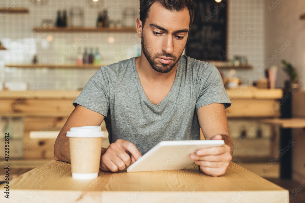 man using tablet in cafe man using tablet in cafe