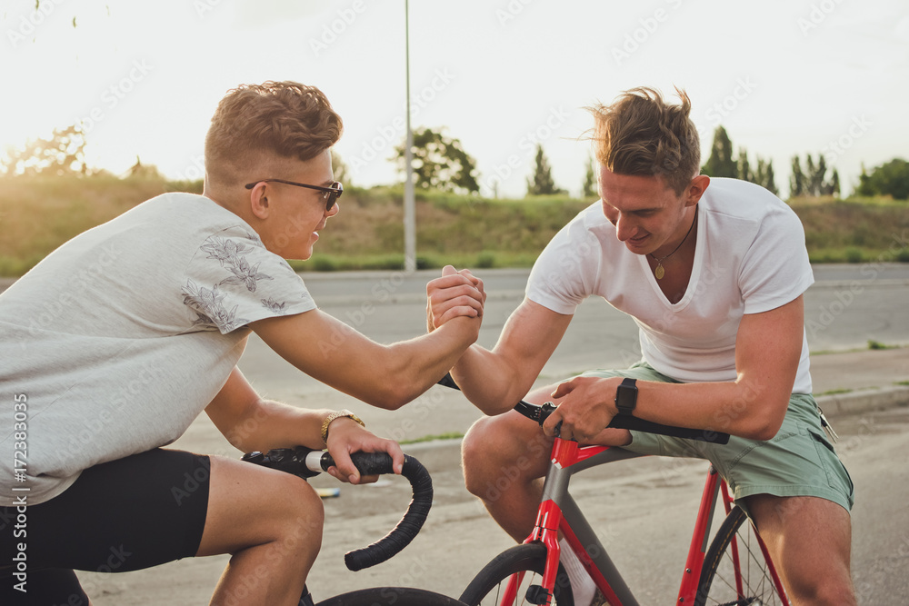 Obraz premium Two cyclists with fixed gear bikes having fun on the road