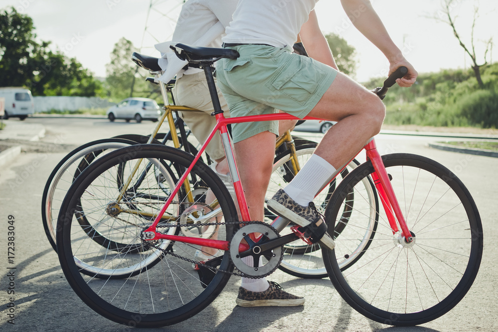 Group of cyclists starting riding fixed gear bikes on the road, close up Group of cyclists starting riding fixed gear bikes on the road, close up