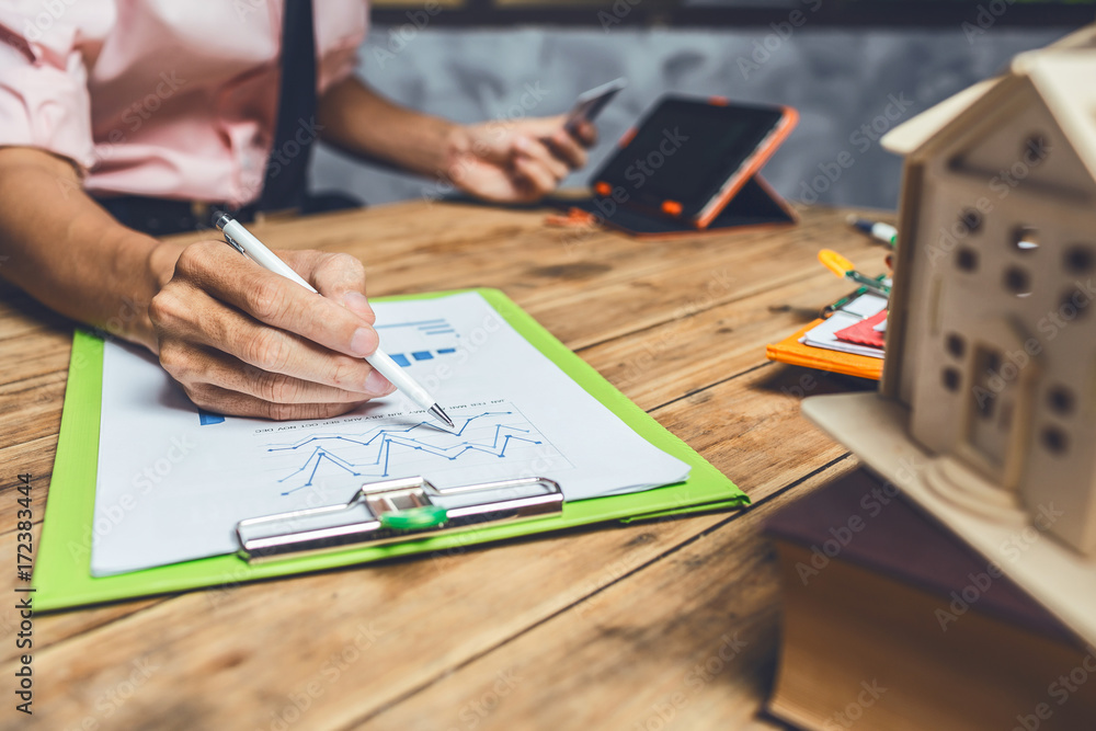 Real estate agent broker working hard to insurance house cash loan for customer service at his office workplace. Real estate agent broker working hard to insurance house cash loan for customer service at his office workplace.