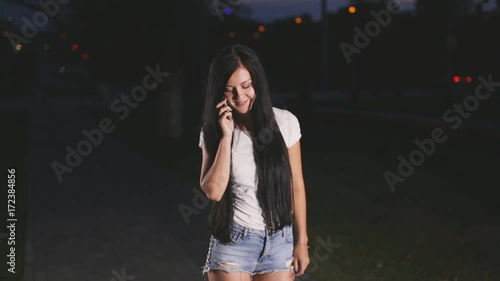 girl is talking on the phone in night city photo