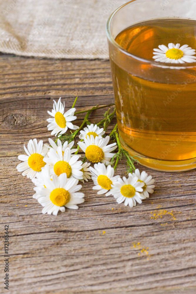 Cup of tea with chamomile flowers on rustic wooden background Cup of tea with chamomile flowers on rustic wooden background