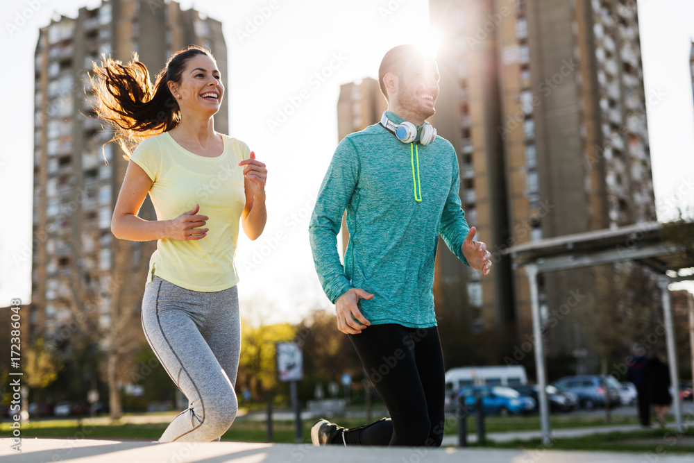 Young attractive couple running outside on sunny day