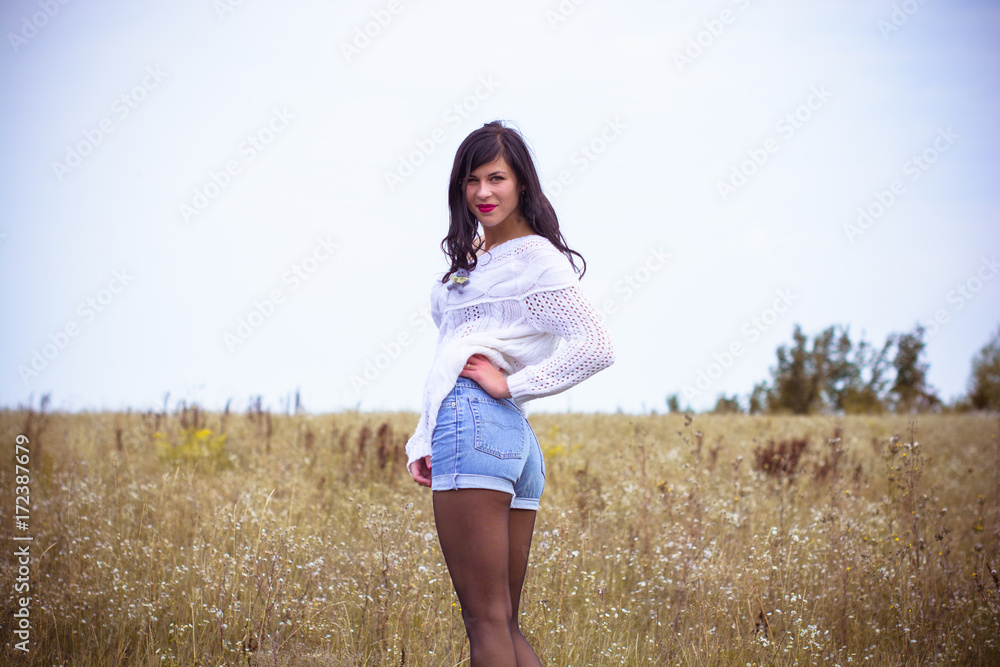 Pretty woman in a white knitted sweater, shorts and boots, stylishly dressed in a field in the fall. A nice and sexy look for beautiful walks and dates at autumn Pretty woman in a white knitted sweater, shorts and boots, stylishly dressed in a field in the fall. A nice and sexy look for beautiful walks and dates at autumn