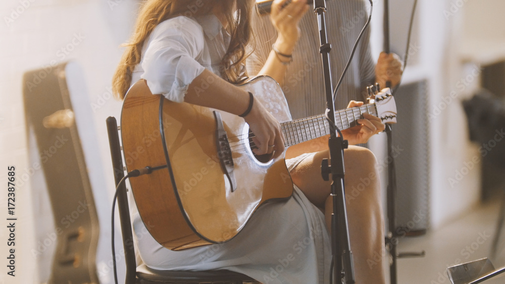 Fototapeta Woman with guitar at stage in loft