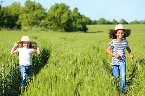 Happy little girls in green field