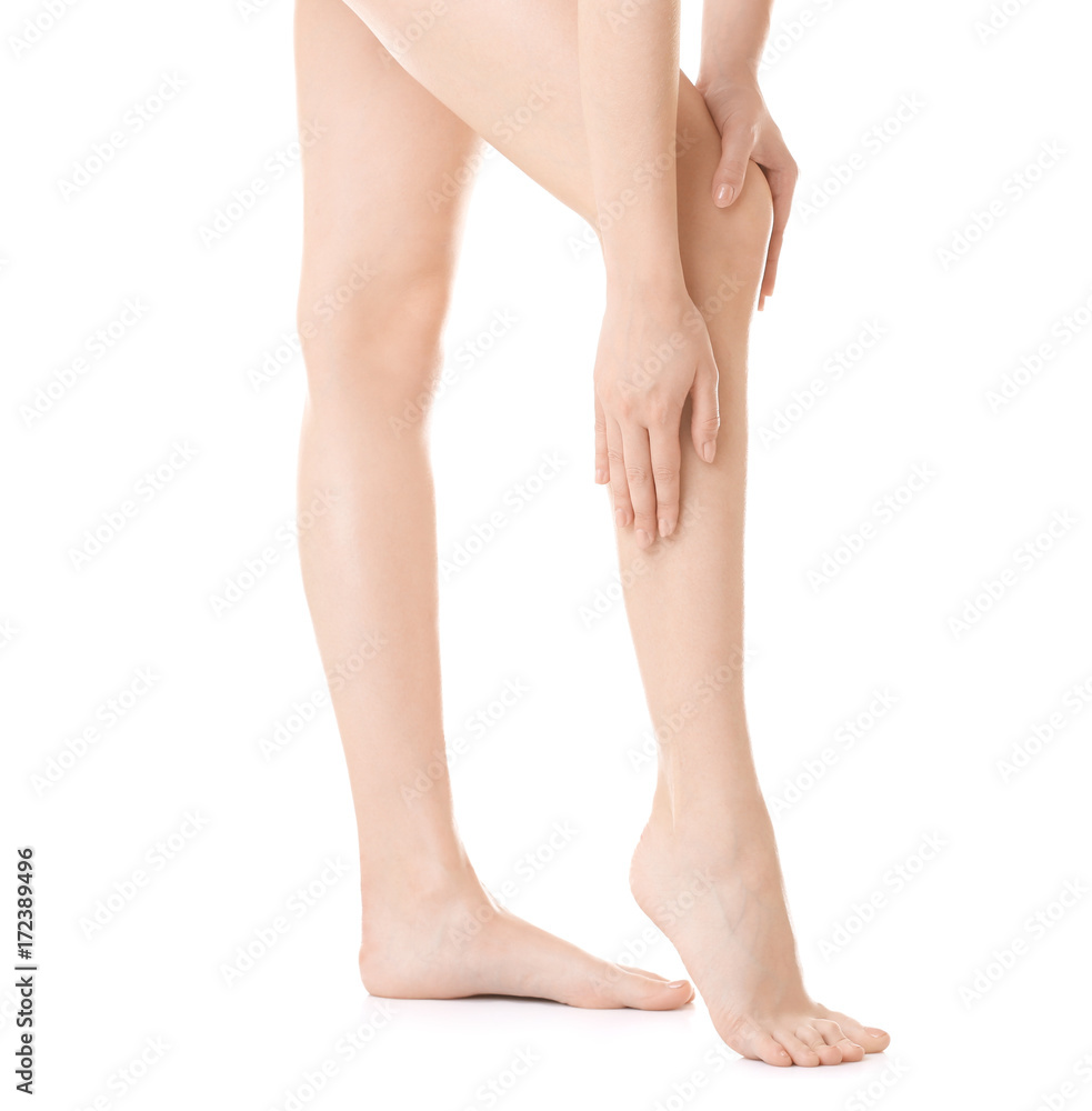 Young woman touching her leg on white background Young woman touching her leg on white background