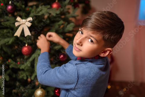 boy decorating christmas tree