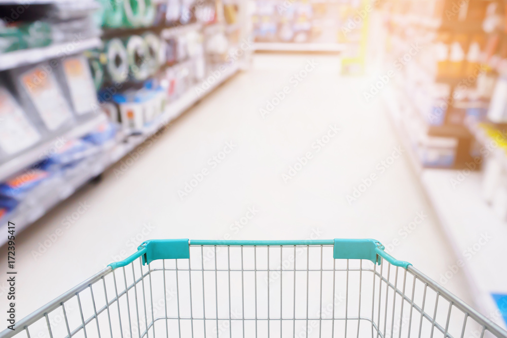 Shopping cart with garden equipment in Supermarket aisle defocused blurred background