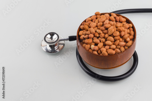 Concept groundnuts isolated white background with stethoscope