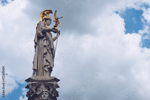 Statue and fountain of Pallas Athena Brunnen, greek goddess of wisdom, in golden helmet in front of Parliament building in Vienna, Austria