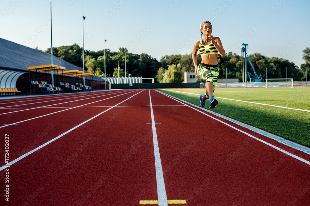A female athlete runs along the treadmill. Sport background A female athlete runs along the treadmill. Sport background