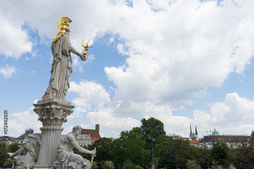 Statue and fountain of Pallas Athena Brunnen, greek goddess of wisdom, in golden helmet in front of Parliament building in Vienna, Austria