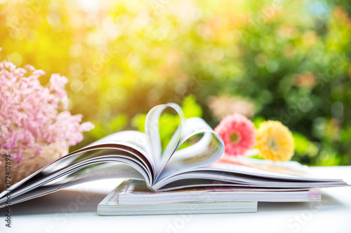 Book with heart shape of paper and there are dry flowers and nature background © Pattanan