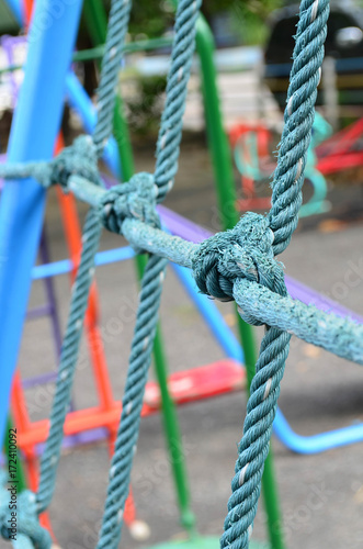 Weathered knot rope climbing net at children playground, as a symbol of trust, teamwork and collaboration