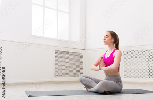 Woman training yoga in lotus pose, copy space