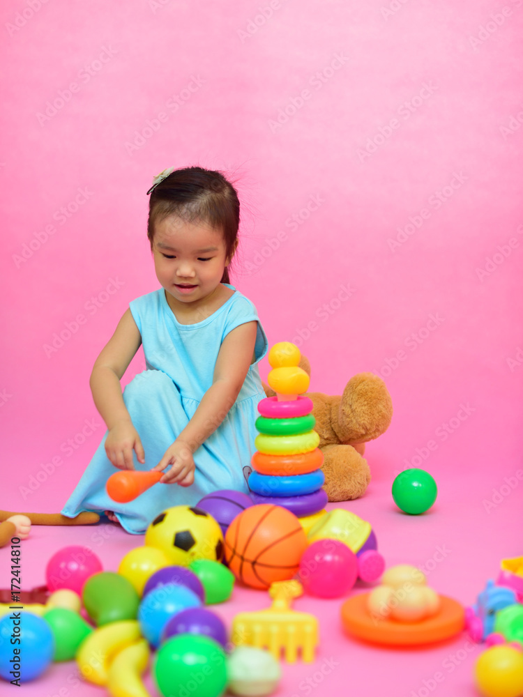 Obraz premium Cute Asian girl playing toys in living room