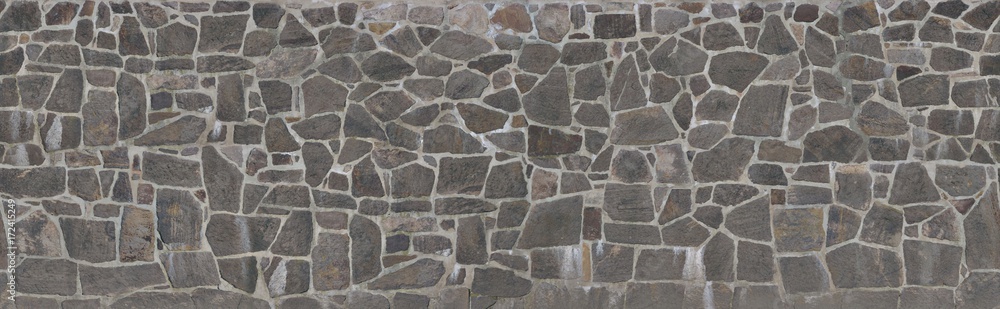 Texture of a stone wall. Old castle stone wall texture background. Stone wall as a background or texture. An example of masonry as a cladding of external walls. 