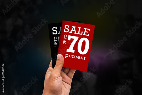black friday concept - hand with a discount ticket isolated on crow people blur background.