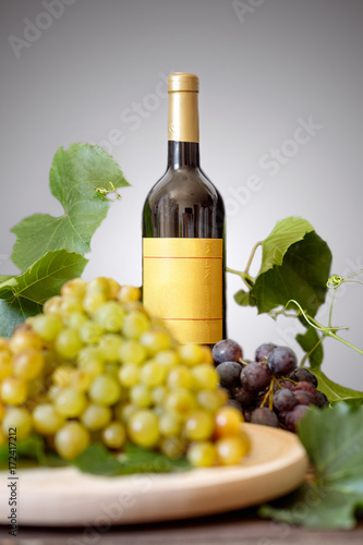 Still life - Bottle of white and red wine, grape on table.