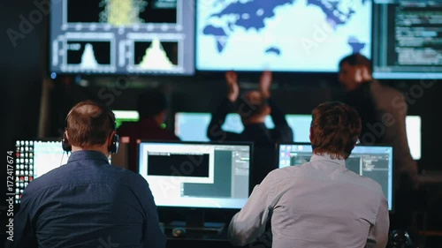Group of People in Mission Control Center filled with Displays, Celebrating Successful Rocket Launch.