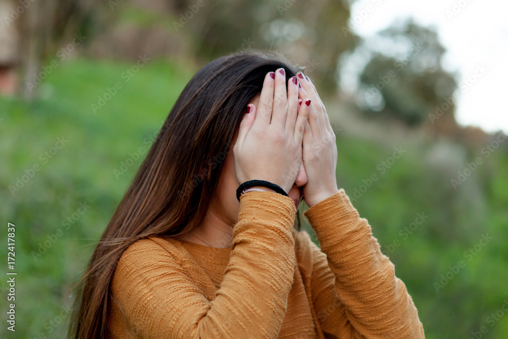 Teenager girl covering her face