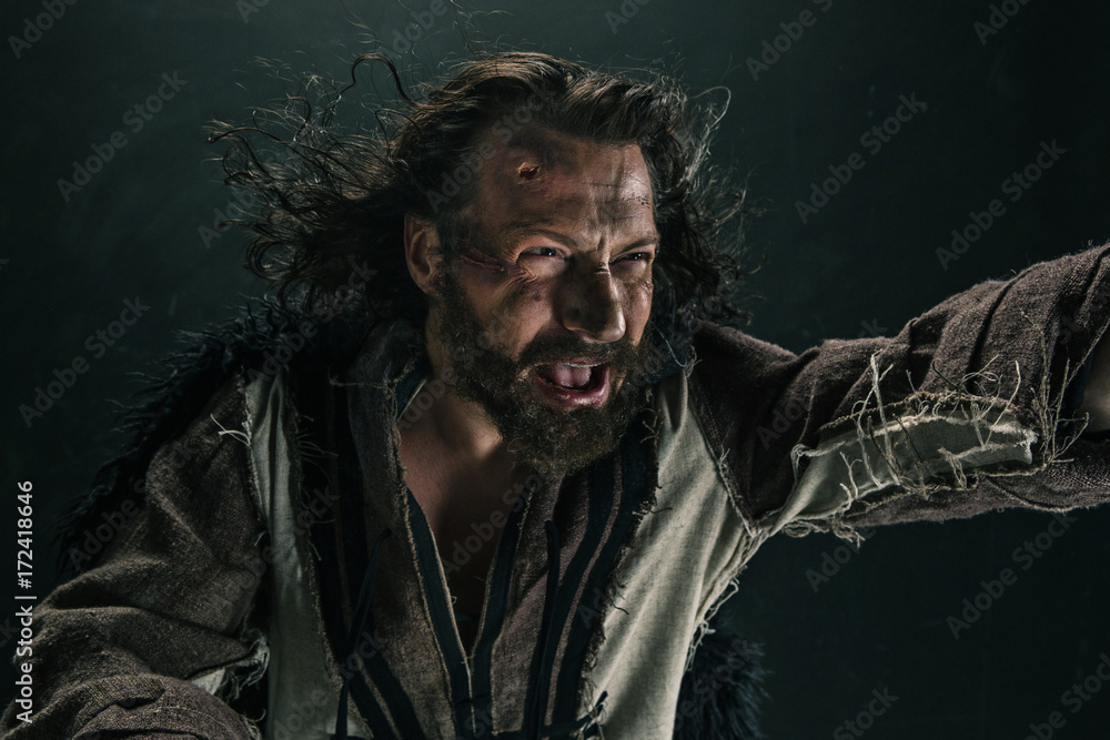Portrait of a brutal bald-headed viking in a battle mail posing against a black background. Portrait of a brutal bald-headed viking in a battle mail posing against a black background.