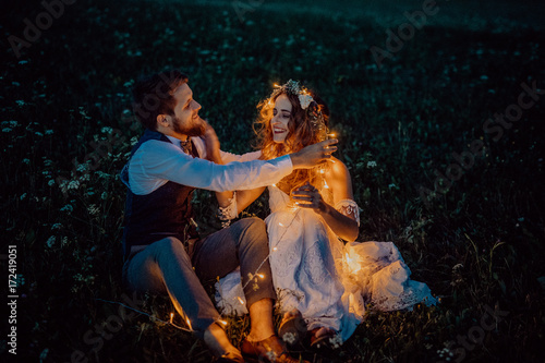 Beautiful bride and groom on a meadow at night. © Halfpoint