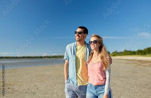 happy couple hugging on summer beach