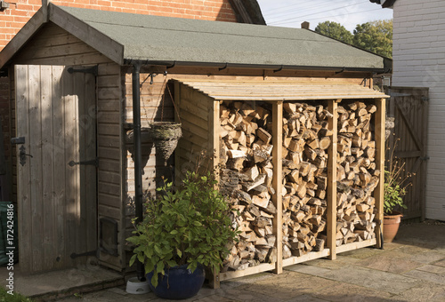 Obraz na płótnie Log store standing against a garden shed